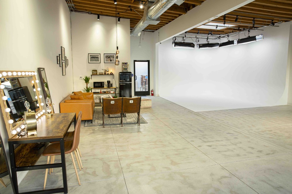 Interior with make-up station, living room set, and white backdrop